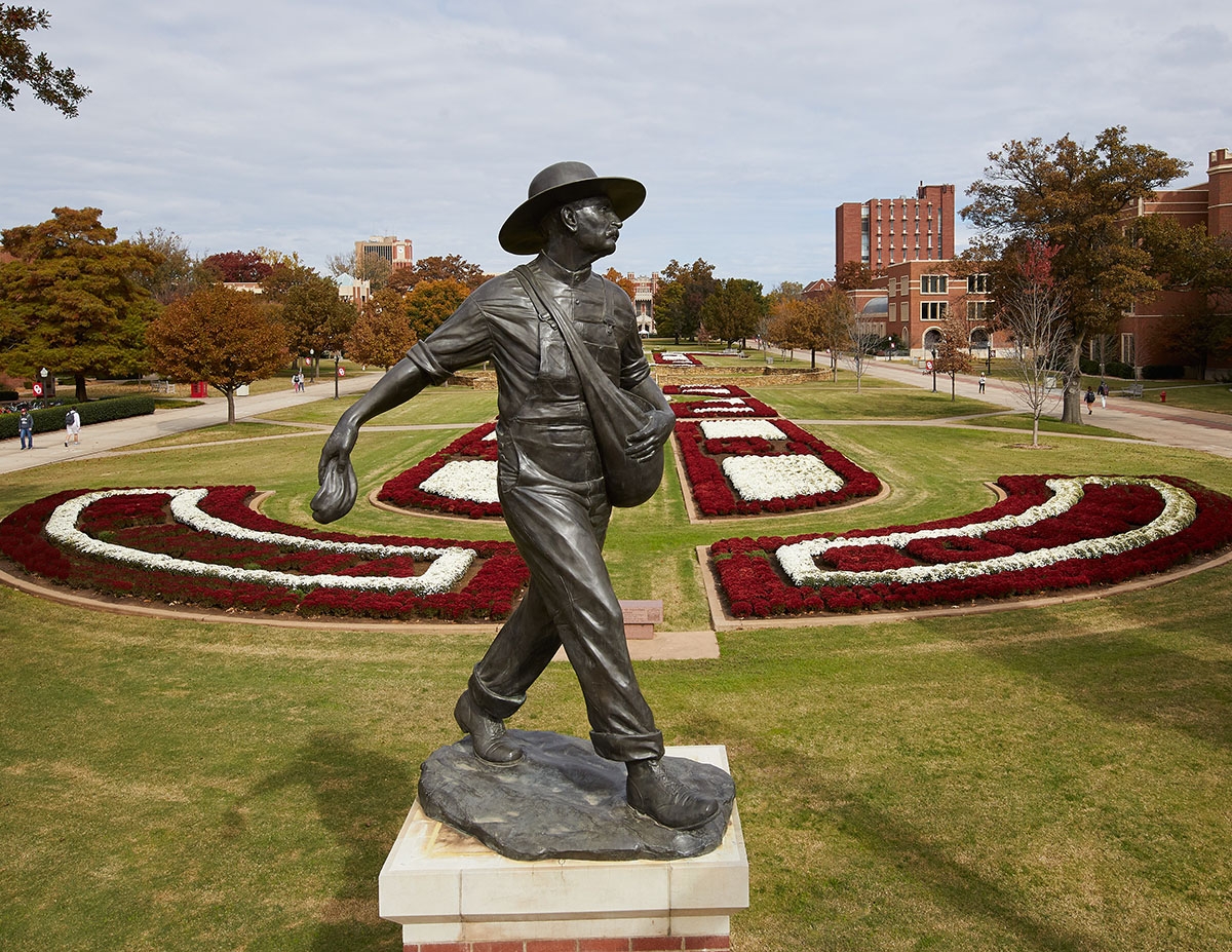 Seed Sower statue on OU campus in Norman, Oklahoma in front of fall mums.