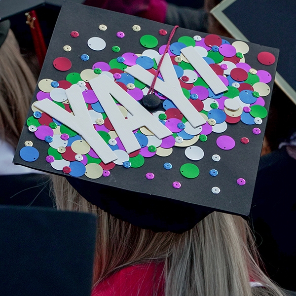 OU student in graduation gear, with YAY! on the top of their hat