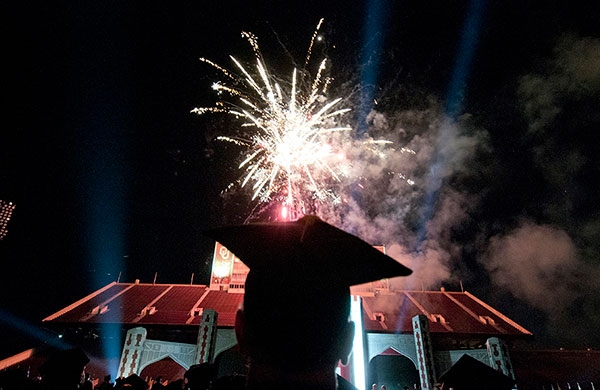 OU Commencement Ceremony is celebrated at the Gaylord Family - Oklahoma Memorial Stadium with fireworks and graduates in the foreground