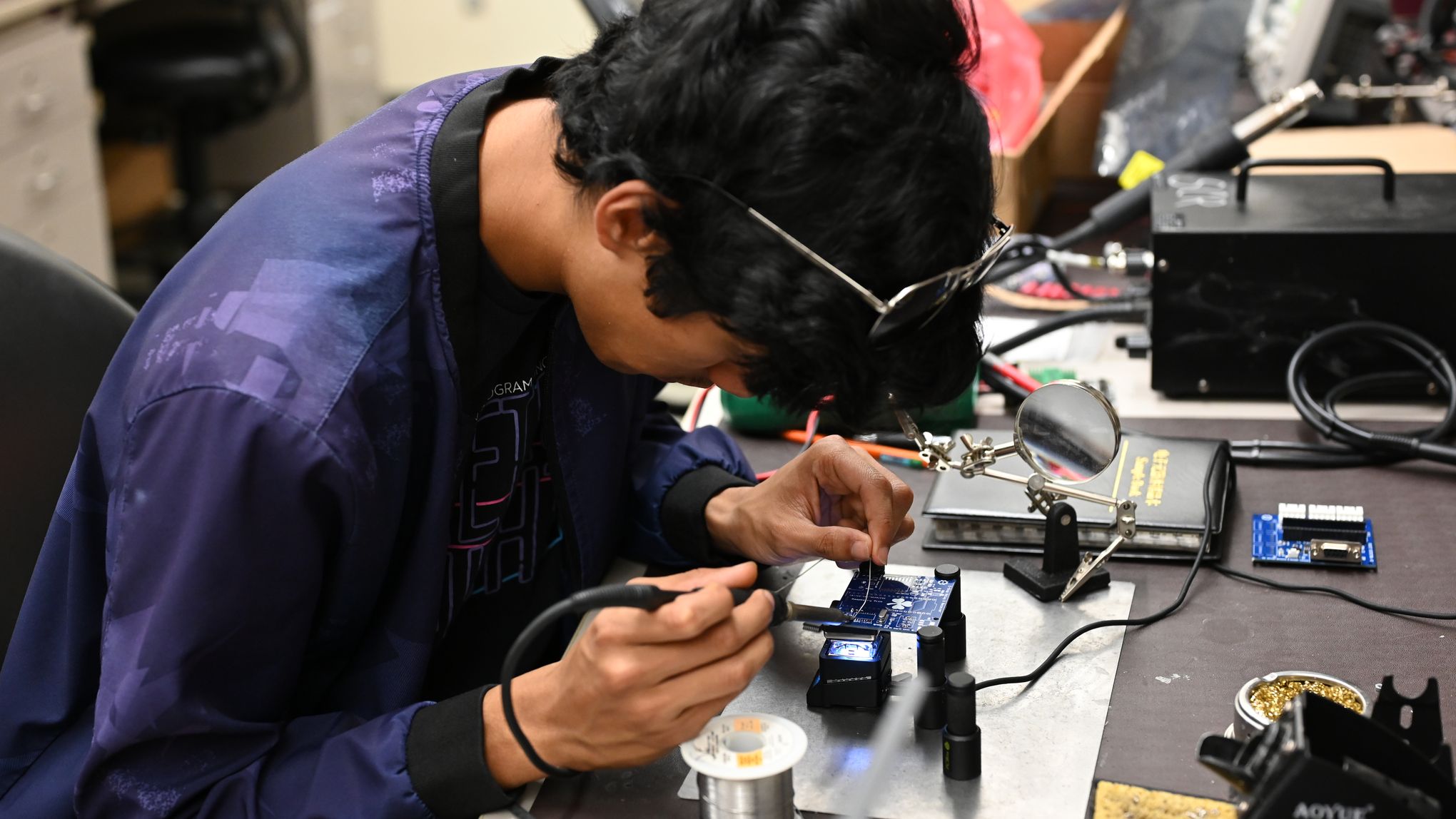 A member soldering a custom PCB